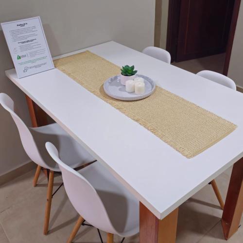 a white table with a plate and a plant on it at Dpto centro CDE in Ciudad del Este