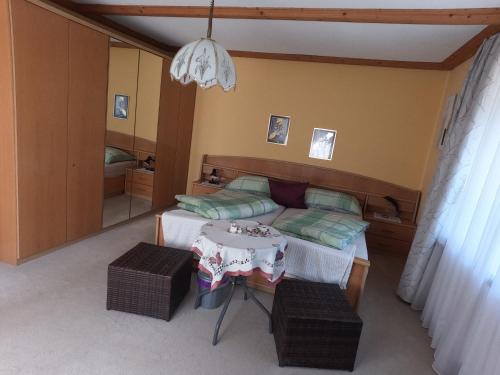 a small bedroom with a bed and a table at Freddys Gästehaus mit 3 Schlafzimmer in Dellach