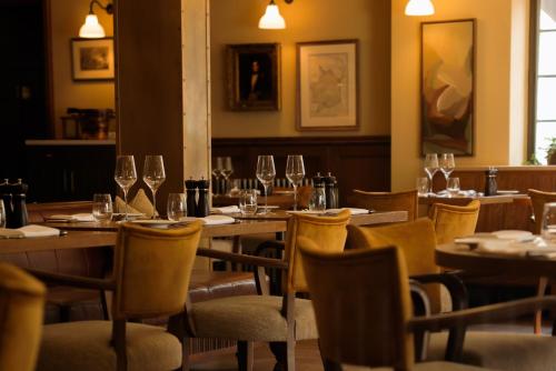 a restaurant with wooden tables and chairs with wine glasses at The Royal George in Tintern