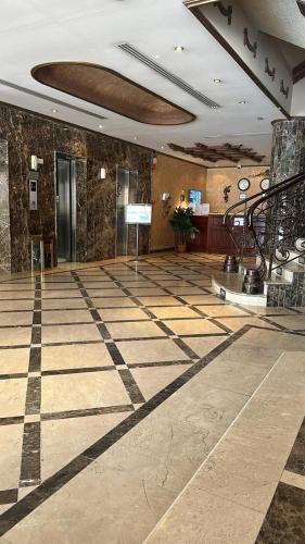 a lobby with a checkered floor in a building at ايواء قمر الشرق للشقق المخدومة in Dammam