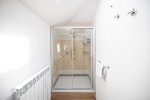 un bagno con doccia con porta in vetro di Splendido Bilocale a Nerviano a Nerviano