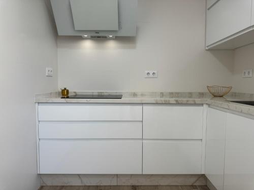 eine weiße Küche mit weißen Schränken und einer Spüle in der Unterkunft Campo de la Verdad Home Luxury in Córdoba