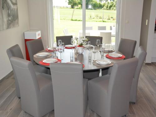 a dining room table with chairs and a table and chairsktop at Modern villa in Rochefort close to the horses in Wavrielle