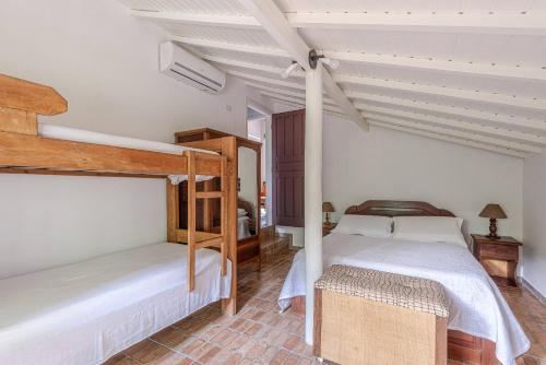 2 Etagenbetten in einem Zimmer mit weißen Wänden in der Unterkunft Camburi 5 quartos com piscina natural in Camburi