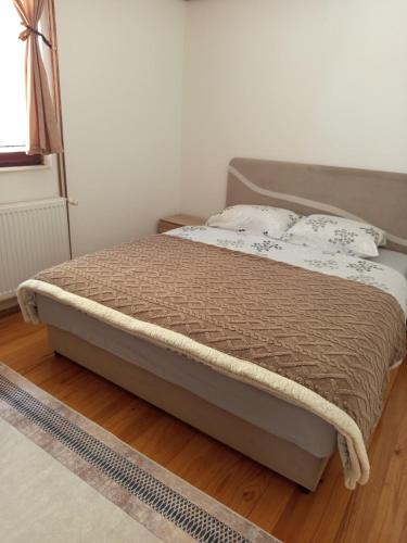 a bed sitting on a wooden floor in a bedroom at Apartman Goga in Pale