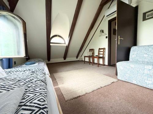 a room with a bed and a couch and a window at Szaletli in Tihany