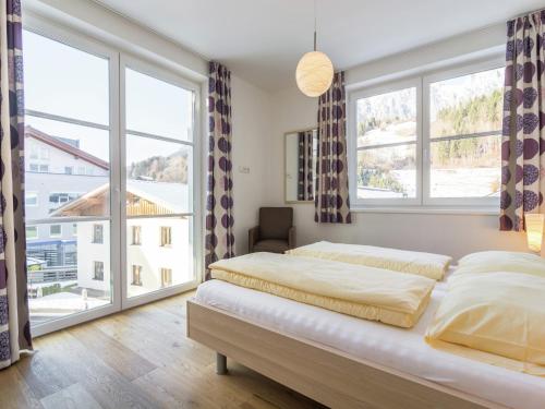 a bedroom with two beds and large windows at Apartment in Leogang near Ski Slopes in Leogang