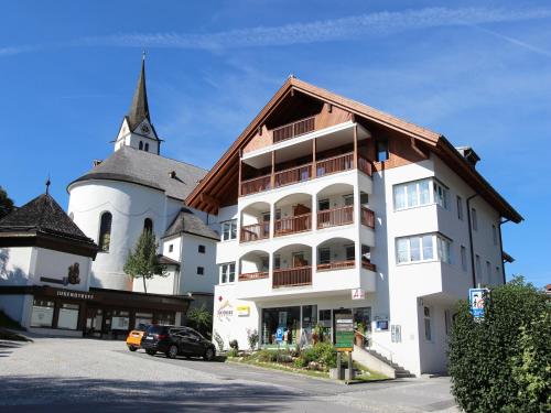 a large white building with a church in the background at Apartment in Leogang near Ski Slopes in Leogang