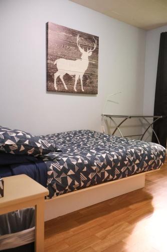 a bed in a room with a picture of a deer on the wall at Chalet Vallée Bras-du-Nord I in Saint-Raymond