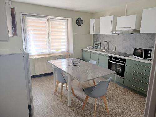 una cucina con tavolo e sedie in cucina di Maison rénovée a Dole