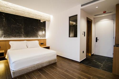 a bedroom with a white bed and a black wall at Thea Experience in Litochoro