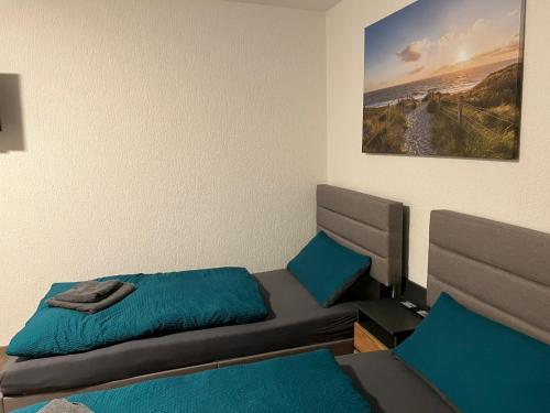 a bedroom with a bed with blue sheets and a painting at HausOase Zimmervermietung Gergert in Schwäbisch Hall
