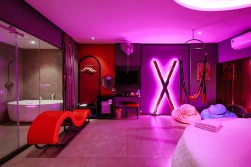 a purple room with a bed and a bathroom with a x sign at khách sạn tina 5 in Can Tho