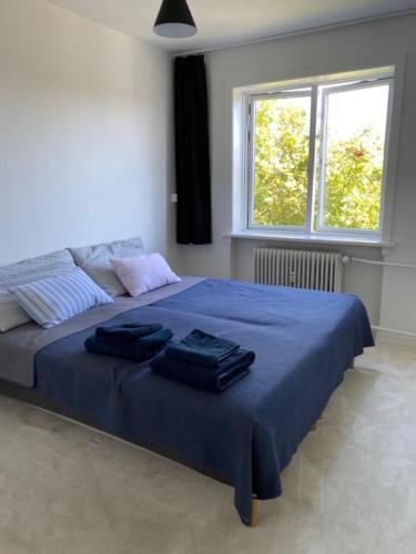 a bedroom with a bed with blue sheets and a window at Comfort & Calm in Copenhagen