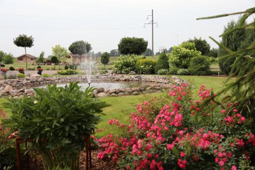a garden with a fountain and pink flowers at Lauras Apartment in Bauska