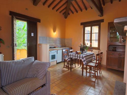 a living room with a table and a kitchen at Farmhouse in Todi with Pool & Theater Nearby in Chioano