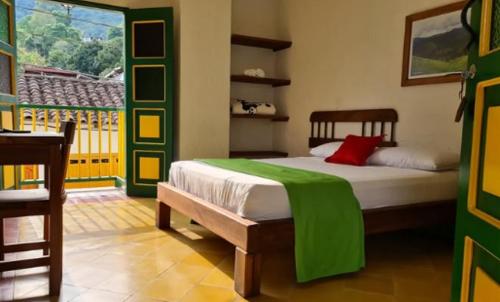 une chambre avec un lit avec une couverture verte dessus dans l'établissement Hotel Vegas del Rio, à Támesis