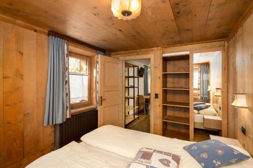 a bedroom with a bed in a room with wooden walls at Engadina Chalet in Livigno