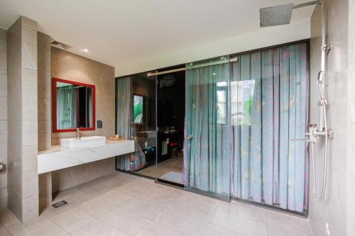 a bathroom with a glass shower and a sink at khách sạn tina 5 in Can Tho