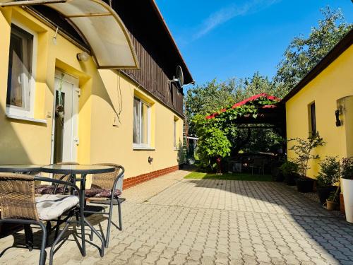a patio with a table and chairs next to two buildings at Privát Ruženka in Liptovský Mikuláš