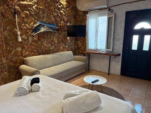 a living room with a couch and a table and a tv at Atlazia Suites in Alinda