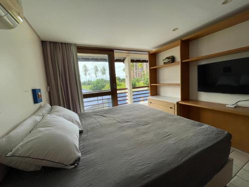 a bedroom with a large bed with a flat screen tv at Casa de Luxo in Paulista