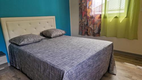 a bed with two pillows on it in a bedroom at Maison charmante à Saint Paul avec vue sur mer in Saint-Paul