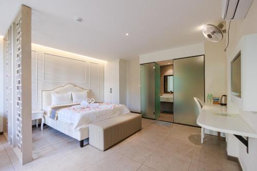 a bedroom with a bed and a desk and a sink at khách sạn tina 5 in Can Tho