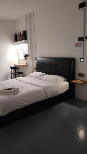 a bed with a black headboard in a room at 23 Inn Queenbed Standard Room in Bukit Mertajam