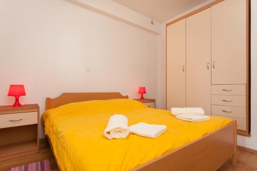- une chambre avec un lit jaune et des serviettes dans l'établissement Apartment Darko, à Rovinj