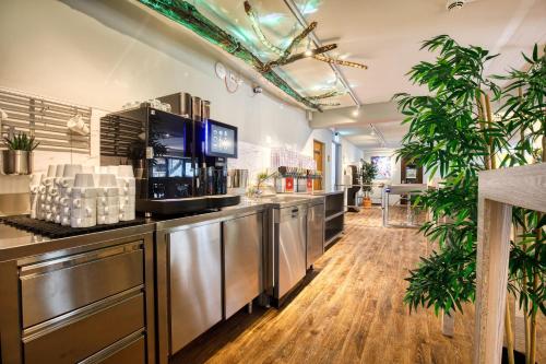 a kitchen with stainless steel appliances and potted plants at Unperfekthotel CoWorkingHotel in Essen