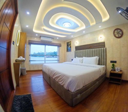 a bedroom with a large bed with a large ceiling at Aarush road lines and holidays in Alleppey