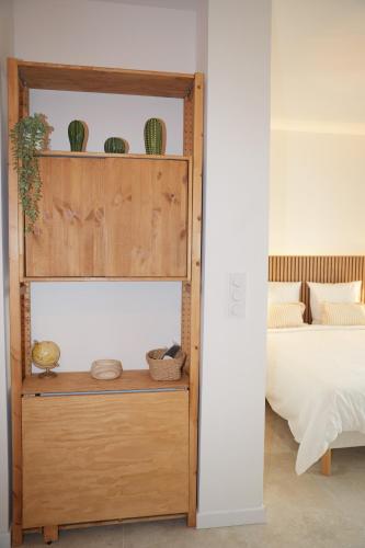 a room with a bed and a shelf with plants at La verrière in Avignon
