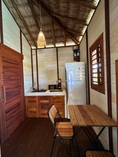 una cucina con un tavolo di legno e un frigorifero di Vila Ammos Beach Houses a Itarema