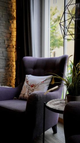 a living room with a blue chair and a table at Hotel am Bergl in Schweinfurt