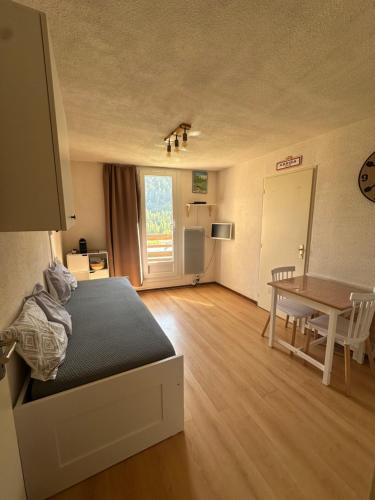 a bedroom with a bed and a table and a door at Studio Pablotin du Queyras in Abriès