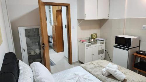a small kitchen with a bed and a microwave at Apto Inteiro Centro Sta Casa 200m WIFI Perto de Tudo até 4 pessoas in Porto Alegre