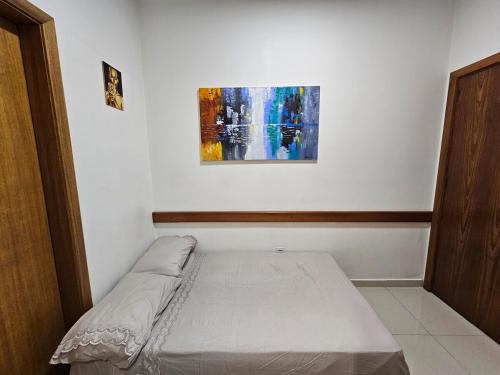 a bed in a room with a painting on the wall at Apto Inteiro Centro Sta Casa 200m WIFI Perto de Tudo até 4 pessoas in Porto Alegre