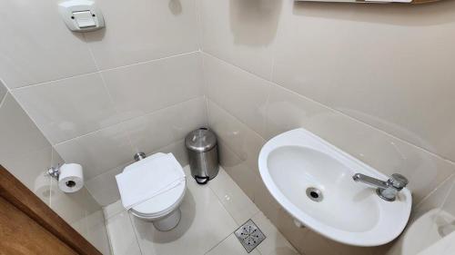 a white bathroom with a toilet and a sink at Apto Inteiro Centro Sta Casa 200m WIFI Perto de Tudo até 4 pessoas in Porto Alegre
