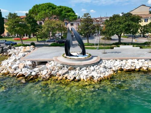 Splendido Apartment DesenzanoLoft Official Partner Homes & Villas by Marriott Bonvoy في ديسينسانو ديل غاردا: تمثال في وسط تجمع الماء