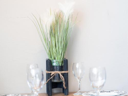 a table with three wine glasses and a plant in a vase at Peaceful Family Home in Elim in Elim