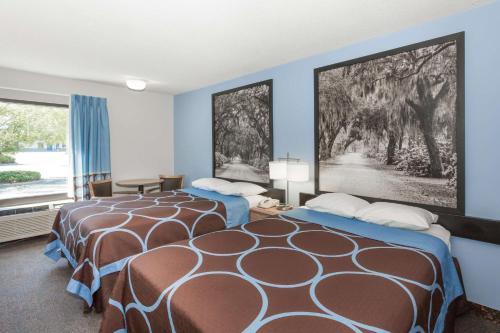 2 camas en una habitación con paredes azules en Super 8 by Wyndham Valdosta GA I-75 en Valdosta