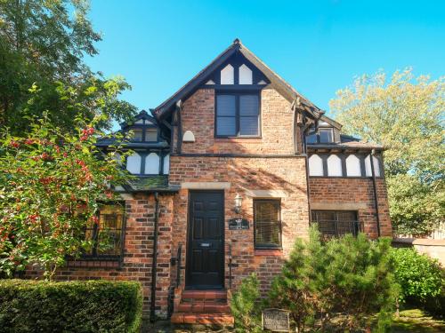 an old brick house with a black door at Detached House with Gated Parking in Whalley Range, Near Manchester City Centre in Manchester