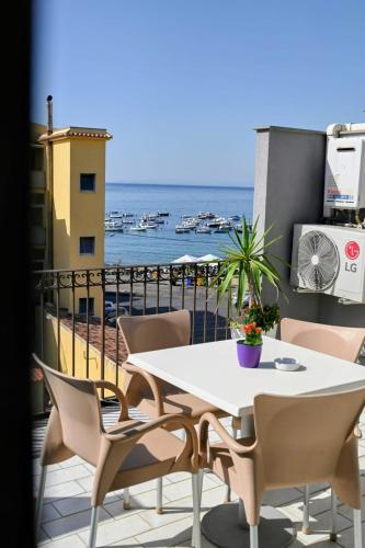 a table and chairs on a balcony with a view of the ocean at Acitrezza B&B in Acitrezza