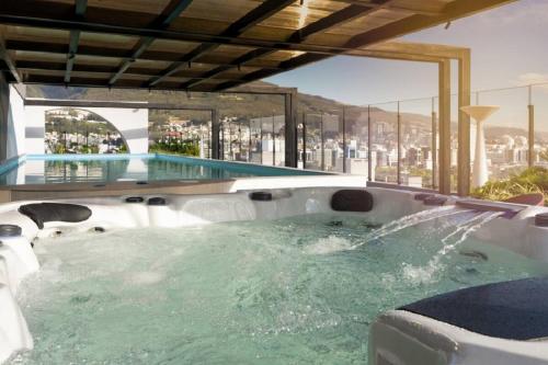a hot tub with a view of a city at Harmony Skyline Suite14th Floor View & Luxury Spa in Quito