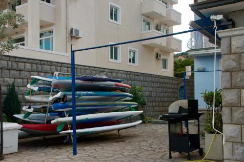 a stack of surfboards on a rack in front of a building at Apart-hotel Villa Lav in Tivat
