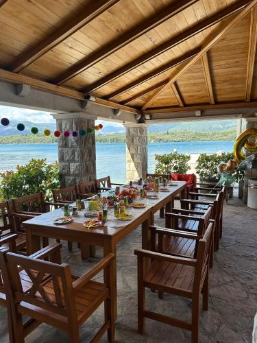 a long wooden table with chairs and food on it at Apart-hotel Villa Lav in Tivat