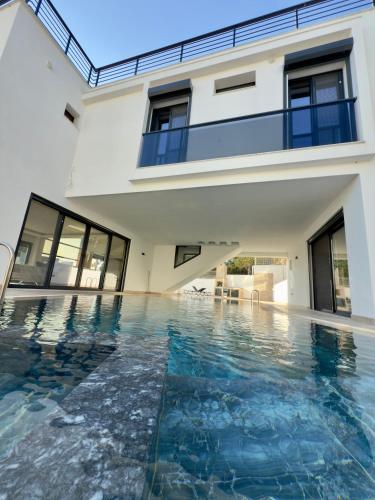 a swimming pool in front of a house at Luxury villa with private pool in Kusadası