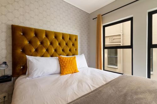 a bedroom with a large bed with a yellow pillow at AlimamaSpaces The Chelsea's Munyaka in Midrand
