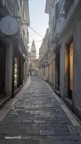 an empty street in an alley with buildings at Istrabella Apartment in Koper